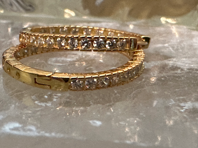 Gold bracelet with diamond accents on a reflective surface