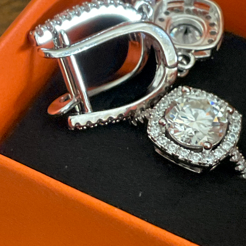 Silver earring with a large gemstone on an orange box