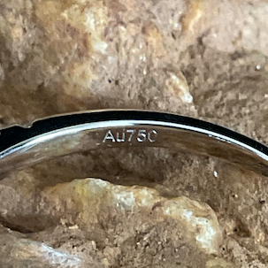 Silver bracelet with a magnifying glass on a stone surface