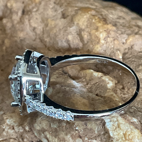 Silver ring with gemstones on a textured stone surface