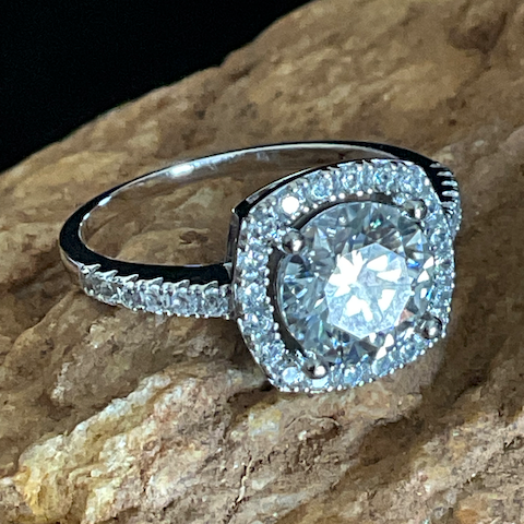 Silver ring with a large diamond on a stone surface