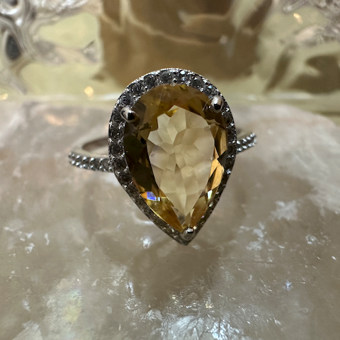Ring with a large teardrop-shaped gemstone on a textured surface