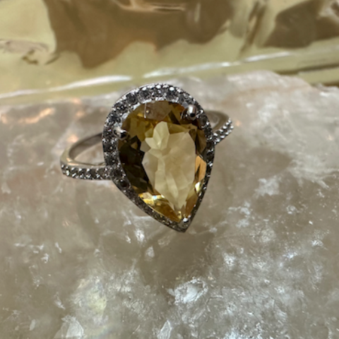 Ring with a yellow gemstone on a crystal surface