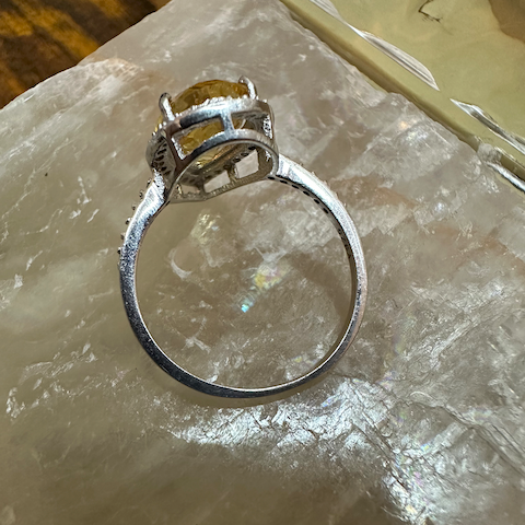 Silver ring with a stone on a textured surface