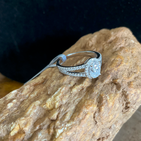 Silver ring with a diamond on a textured stone surface