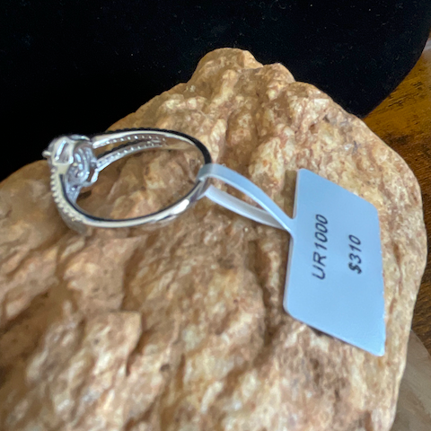 Silver ring on a textured surface with a price tag attached
