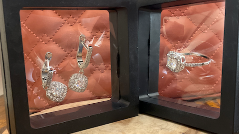 Quilted pink pouch with jewelry display on a wooden stand