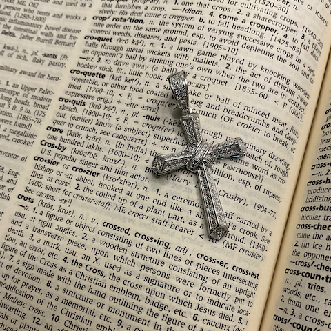 Decorative cross on an open dictionary page