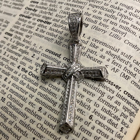 Silver cross pendant on an open dictionary page