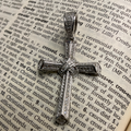 Silver cross pendant on an open dictionary page