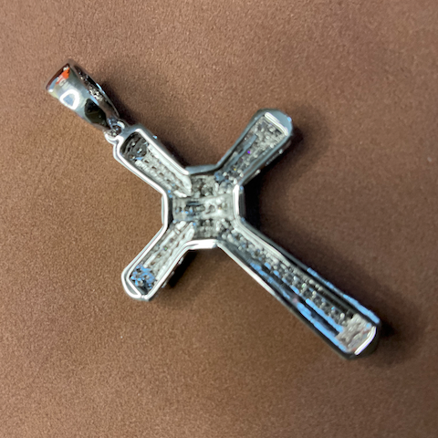 Silver cross pendant on a brown background