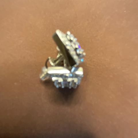 Pair of diamond-studded earrings on a brown surface