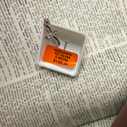 Small jewelry display with a tag on a newspaper background