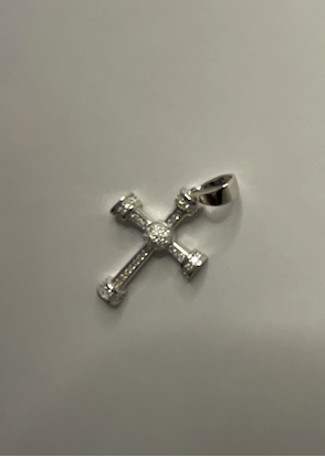 Silver cross pendant on a light gray background