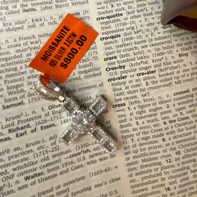 Silver pendant with orange tag on a book page