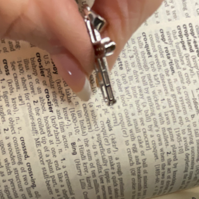 Hand holding a key above an open book with text.