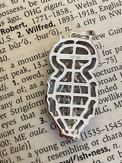 Silver anklet charm on an open book with text