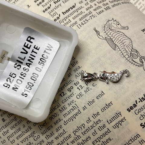 Silver necklace with a tag on an open book