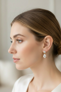 Woman wearing smaller gold moissanite teardrop dangle earrings