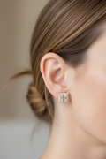 Woman wearing square gold moissanite stud earrings